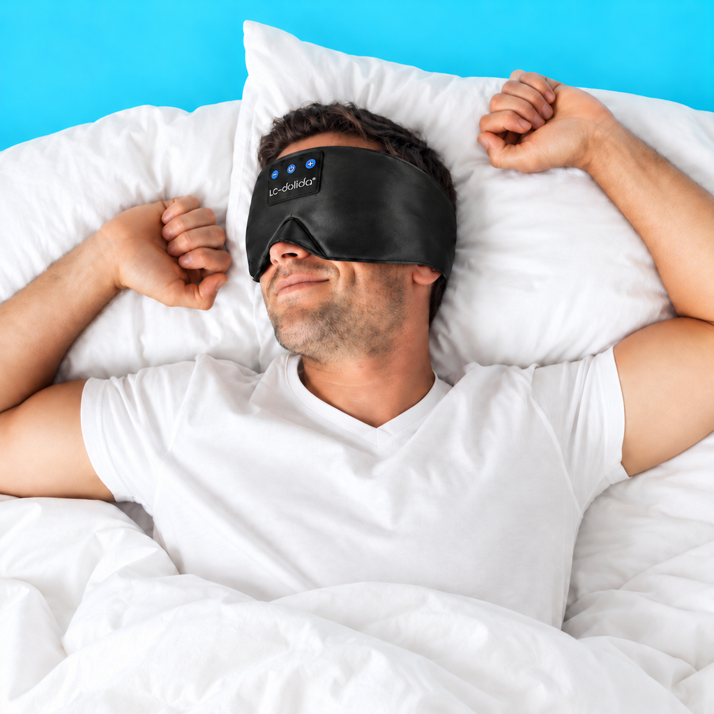 Man resting on his back wearing a black silk Bluetooth sleep mask