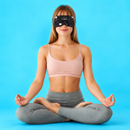 Woman meditating while wearing a black space-print sleep mask