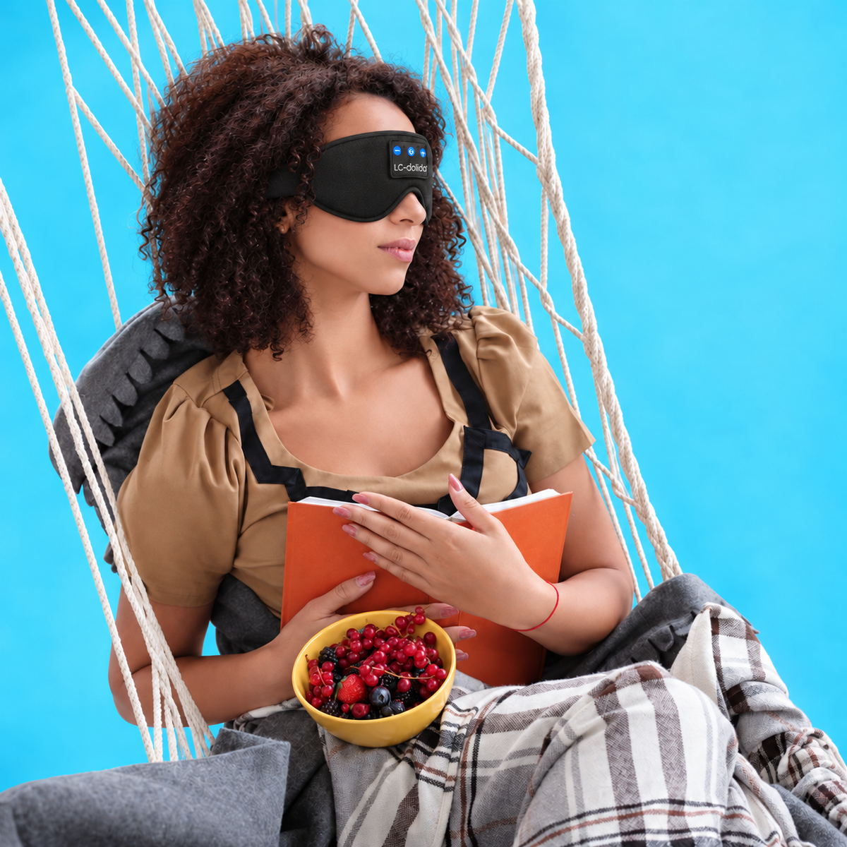 Woman relaxing in a hammock wearing an LC-dolida Bluetooth sleep mask.